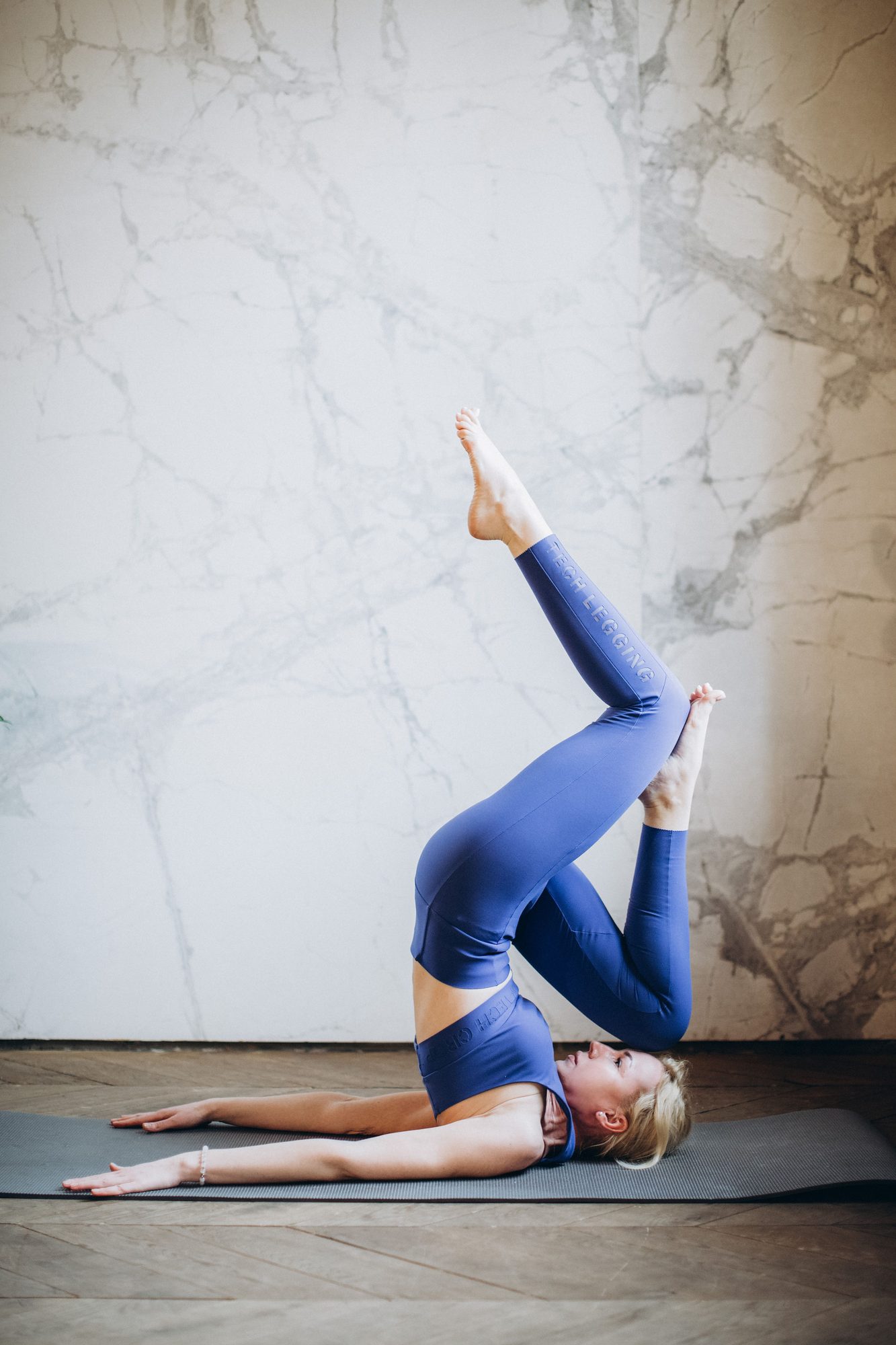 A woman on a mat against a marble wall